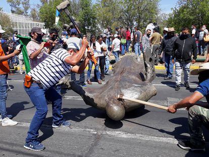 Miembros del Consejo Indígena destruyen la estatua de Fray Antonio de San Miguel en Morelia, el lunes.