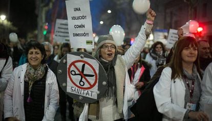 Una manifestante sostiene un cartel pidiendo la dimisión del consejero de salud, Toni Comin.