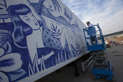 El artista Sergio Mora pinta en la caja de un camión.
