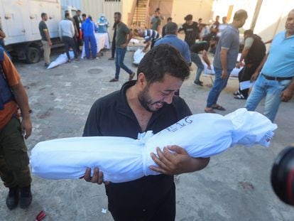 Un palestino lleva el cuerpo de un niño muerto en ataques israelíes, en el hospital Shuhada Al-Aqsa, en el centro de la Franja de Gaza, este martes.