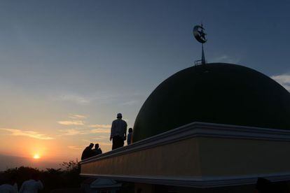 Musulmanes indonesios se disponen a ver la luna llena desde lo alto de una mezquita en Yakarta.