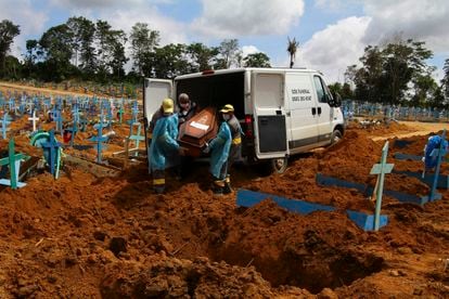 Trabajadores de un cementerio llevan los restos de un hombre que murió a causa del coronavirus, para enterrarlos en el cementerio Nossa Senhora Aparecida en Manaus, estado de Amazonas, Brasil, el pasado 6 de enero.