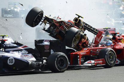El coche de Romain Grosjean vuela por encima del de Fernando Alonso tras provocar que le embistiera el de Lewis Hamilton.