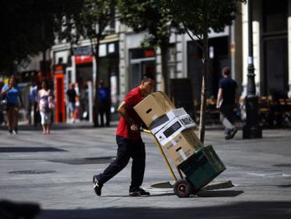 Un repartidor transporta varias cajas en el centro de Madrid