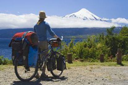 Una cicloturista contemplando el volcán Osorno, en la región de Los Lagos, en Chile.