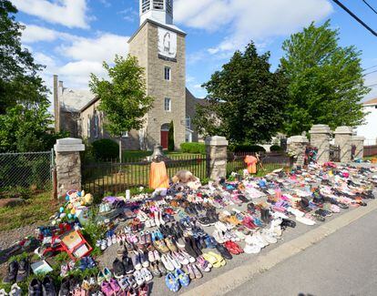 Flores y zapatos infantiles colocados frente a una iglesia en protesta tras el hallazgo de los restos de 215 niños en un orfanato.