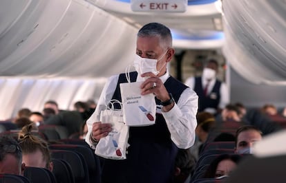 Un sobrecargo de American Airlines reparte bolsas de refrigerios a bordo de un avión Boeing 737 Max antes de despegar del aeropuerto de Dallas Fort Worth en Grapevine, Texas.