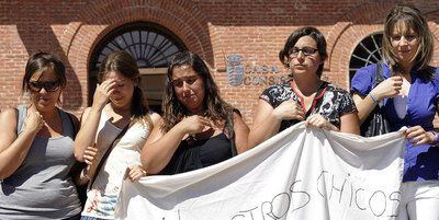 Varias de las cuidadoras del centro Nuevo Amanecer, de Boecillo (Valladolid), donde se produjo la tragedia sostienen el pasado día 16 una pancarta en recuerdo de los menores fallecidos.