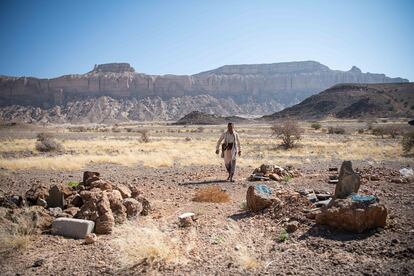 El traficante yemení Ahmed al Dabsi, junto a varias tumbas de migrantes ahogados en las costas de Yemen.