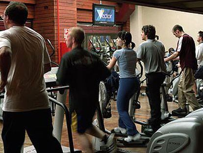 Varias personas hacen ejercicio durante una sesión deportiva en un gimnasio madrileño.