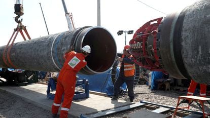 Dos trabajadores instalan una tubería del gasoducto Nord Stream 2 cerca de Kingisepp, en la región rusa de Leningrado, en una fotografía de junio de 2019.