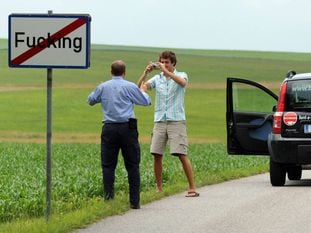 Dos turistas se hacen una fotografía junto a una señal del pueblo de Fucking (Austria).