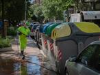 Un operario de limpieza del servicio municipal desinfecta un contenedor.