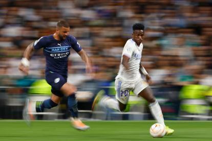 El delantero Real Madrid Vinicius Junior (d) escapa de Kyle Walker, del Manchester City, durante el partido de semifinales de la Liga de Campeones. 