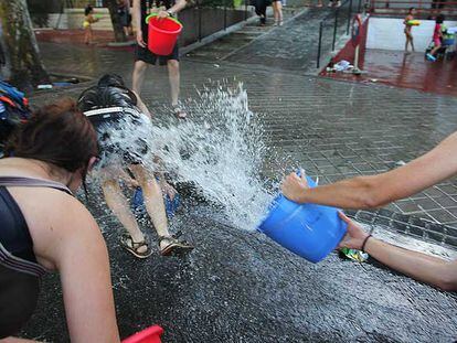 Participantes en la Batalla Naval de Vallecas se arrojan cubos de agua en la calle.
