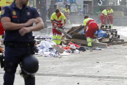 Los servicios de limpieza municipales retiran los restos del punto de información el 15-M en la Puerta del Sol.