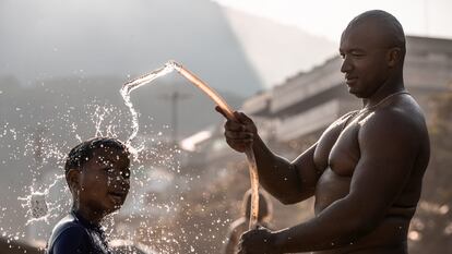 Un hombre baña a su hijo, en Río de Janeiro.