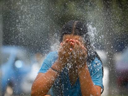 Una joven se refresca en una fuente de una calle de Córdoba, el viernes.