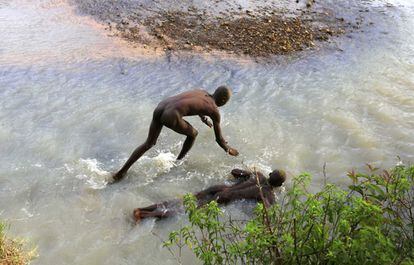 Muchachos Bukusu se sumergen en agua fría en un río para adormecer sus cuerpos como parte de la preparación del ritual de la circuncisión, en el que no pueden ni pestañear.