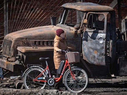 A resident walks near a destroyed Russian truck in the northeastern city of Trostianets, on March 29, 2022. - Ukraine said on March 26, 2022 its forces had recaptured the town of Trostianets, near the Russian border, one of the first towns to fall under Moscow's control in its month-long invasion. (Photo by FADEL SENNA / AFP)