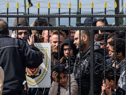 Migrantes esperan a ser atendidos por oficiales turcos, en Esmirna (Turqu&iacute;a).