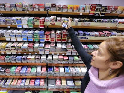 Una estanquera muestra cajetillas de tabaco de distintas marcas.