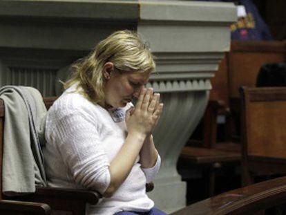 Una mujer reza mientras asiste al debate en el Senado de Uruguay.