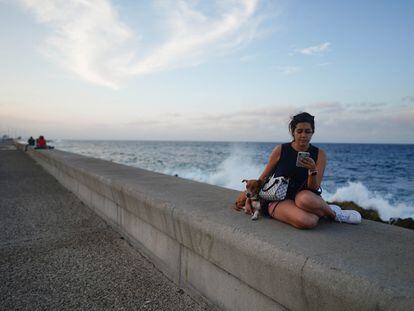 Dayamis Ramirez, de 25 años, navega en Internet en el Malecón de La Habana, Cuba, el 7 de febrero 2023.