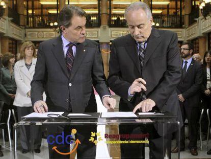 Artur Mas y el líder de la formación independentista, Reagrupament, el exconsejero Joan Carretero, firman el acuerdo de colaboración.