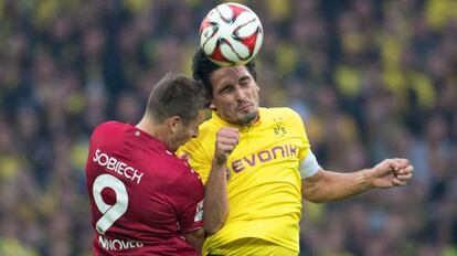 Hummels despeja el balón de cabeza ante Sobiech, del Hannover 96