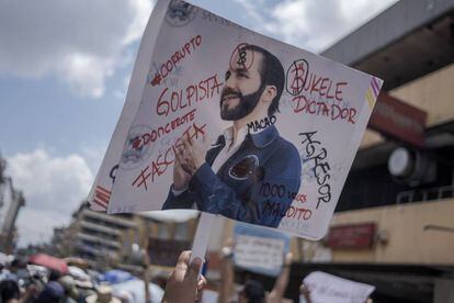 Un manifestante levanta una pancarta en contra del presidente de El Salvador, Nayib Bukele