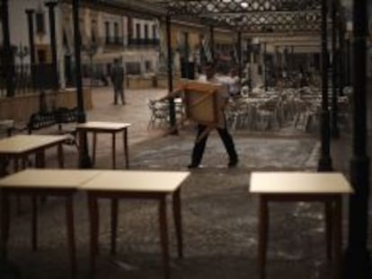 Un camarero recogiendo mesas en un restaurante en Sevilla. 