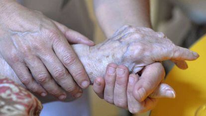 Una persona atiende a una anciana.