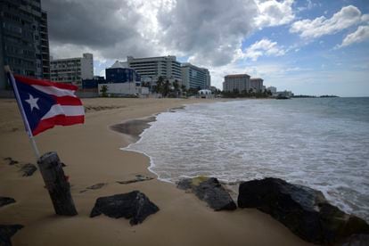 Una bandera puertorriqueña ondea en una playa vacía en Ocean Park, en San Juan, Puerto Rico, el jueves 21 de mayo de 2020.