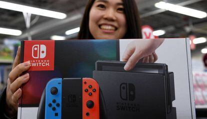 Una joven compra la consola Nintendo Switch en una tienda en Tokio, Japón.