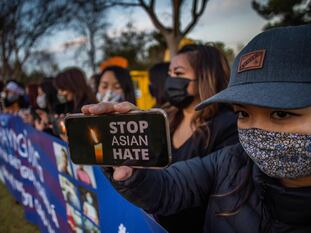 Una mujer sostiene un móvil con la frase "detengan el odio a los asiáticos" en una vigilia este miércoles, en California.