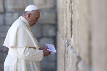 El Papa guarda una nota en un sobre antes de colocarlo entre las piedras del Muro de las Lamentaciones en Jerusalén.