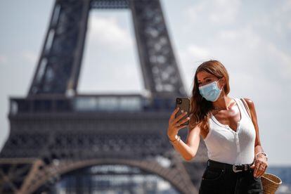 Una mujer se toma un selfi en el Trocadero, frente a la Torre Eiffel, este 9 de agosto.