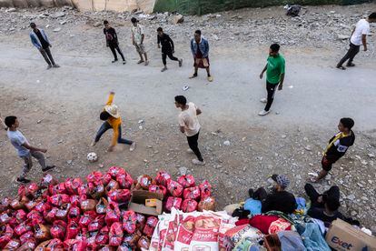 Un grupo de jóvenes juega al fútbol durante un descanso del reparto de ayuda en Souk, Aghbar. 