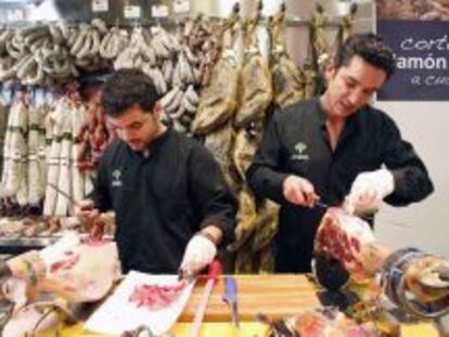 Dos trabajadores cortando jam&oacute;n en Viandas de Salamanca (Madrid)