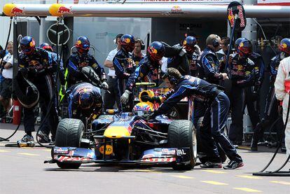 Mecánicos de Red Bull conducen el monoplaza de Mark Webber al interior del garaje durante la clasificación