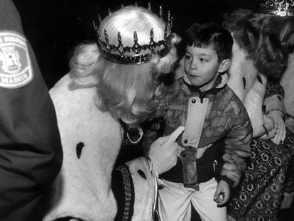 Un niño atiende los consejos del rey Melchor en la fiesta de los Reyes Magos de los hijos del cuerpo de Bomberos de Madrid en 1991