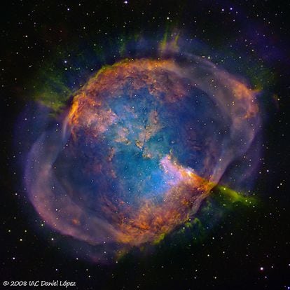 La nebulosa Dumbbell, o M27, fue descubierta en 1764 por Charles Messier. Fue la primera nebulosa planetaria observada y una de las más impresionantes de todo el cielo. Su nombre en inglés proviene de la forma que presenta a través de un telescopio, que recuerda a una pesa o mancuerna. Su edad está estimada en unos 4.000 años y está situada a unos 500 años luz de la Tierra. La visión que tenemos de ella es aproximadamente desde su plano ecuatorial. La nebulosa Dumbbell es visible a través de unos binoculares como una pequeña esfera partida difusa. Es con un telescopio de mediana apertura cuando empieza a presentar detalles sutiles de su estructura interna. Esta imagen se ha tomado con el telescopio IAC80 en el Observatorio del Teide (Islas Canarias), del Instituto de Astrofísica de Canarias. Comentario: Pablo Rodríguez Gil y Álex Oscoz Abad.