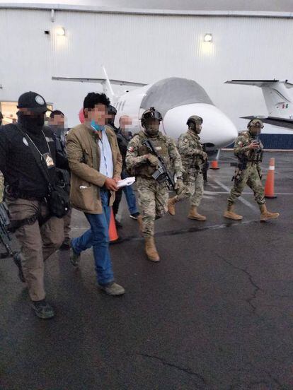 Elementos de la Marina escoltan a Caro Quintero en la pista de un aeropuerto para continuar con su traslado al penal del Altiplano.