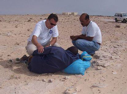 Miembros de la ONG Médicos del Mundo con uno de los inmigrantes encontrados en el desierto
