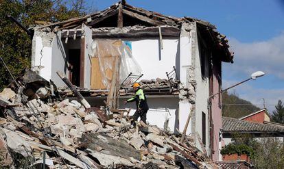 Un bombero busca entre los escombros de un edificio en el pueblo italiano de Borgo Sant'Antonio.