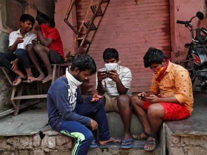 Un grupo de jóvenes consulta sus móviles en Bombay.