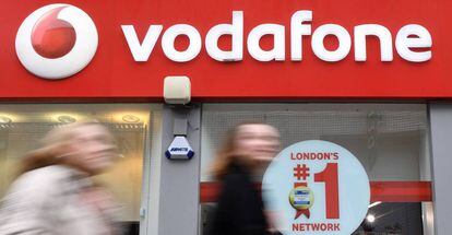 Varios viandantes pasan delante de un establecimiento de la compañía de telecomunicaciones Vodafone en Londres (Reino Unido). 