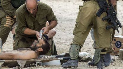 Soldados israelíes evacúan a un herido.