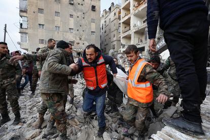 Personal de rescate recupera el cadáver de una persona de entre los escombros de un edificio en Alepo (Siria). 